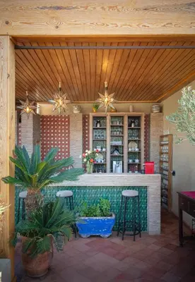 a patio with a bar with stools and plants at Riad Fleur d'Orient in Marrakech