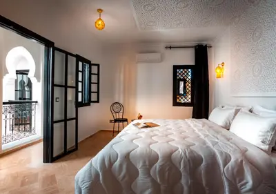 a bedroom with a large white bed and a window at Riad Tamazgha in Marrakech