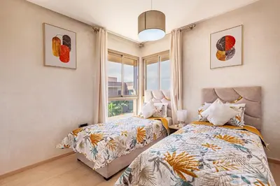 a bedroom with two beds and a window at Luxury Living Flat in Prestigia Marrakech in Marrakech