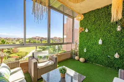 a living room with a green wall at Luxury Living Flat in Prestigia Marrakech in Marrakech