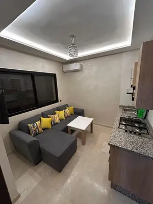 a living room with a couch and a table at Studio au centre ville de marrakech avec piscine in Marrakech