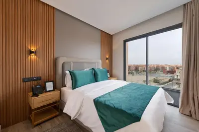 a bedroom with a large bed and a large window at Appart Hôtel Rambla in Marrakech