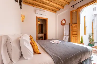 a bedroom with a large bed with white pillows at Riad Mama in Marrakech
