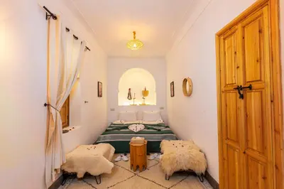 a room with a bed and two chairs in it at Riad Mama in Marrakech
