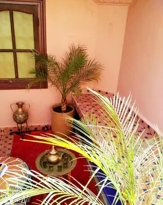 a room with two potted plants and a table at Riad yazuinaa in Marrakech