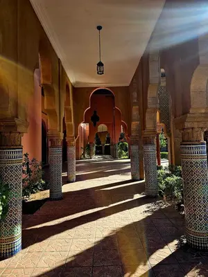 a hallway of a building with columns and a ceiling at Riad yazuinaa in Marrakech