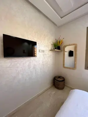 a bedroom with a flat screen tv on the wall at Yumo: The Cozy One in Marrakech