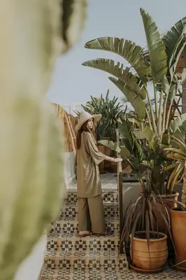 a woman standing next to a potted plant at Riad Dar M in Marrakech