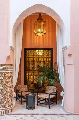 a lobby with two chairs and a chandelier at Riad Dar Al Dall - This Time Tomorrow in Marrakech in Marrakech
