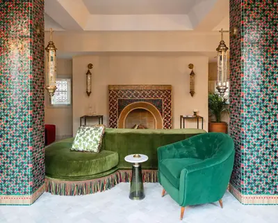 a living room with a green couch and a chair at Riad Dar Al Dall - This Time Tomorrow in Marrakech in Marrakech