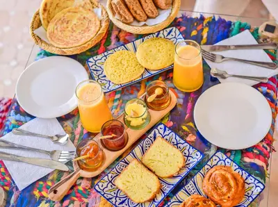 a table with plates of food and glasses of orange juice at Riad Zayn & Spa in Marrakech