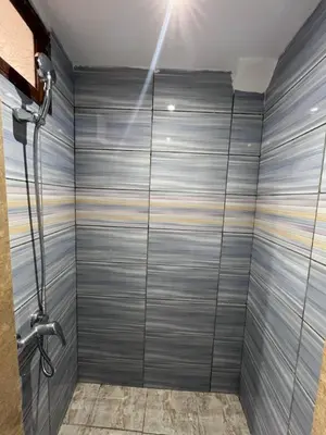 a shower in a bathroom with a gray wall at Riad Dar Zarbia in Marrakech
