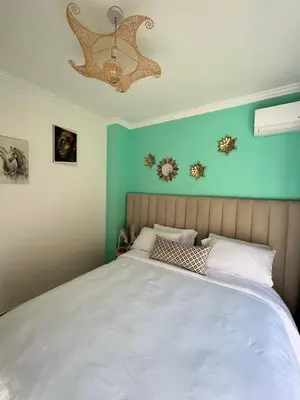 a bedroom with a large white bed and a chandelier at Charming Appartment in Gueliz in Marrakech