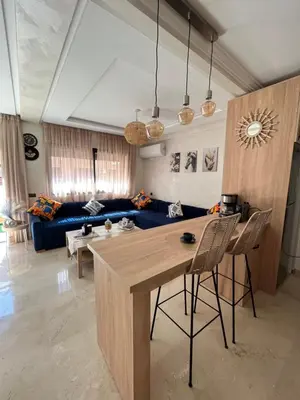 a living room with a table and a blue couch at Charming Appartment in Gueliz in Marrakech