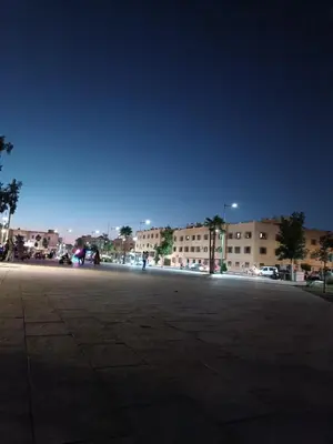 an empty parking lot at night with buildings in the background at Airport Home in Marrakech