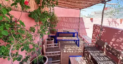 a patio with benches and a table and chairs at Couloirs de la Médina in Marrakech