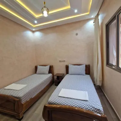 two beds in a room with a ceiling at Bel appartement de 2 chambres L in Marrakech