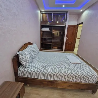 a bedroom with a bed with a laptop on it at Bel appartement de 2 chambres L in Marrakech