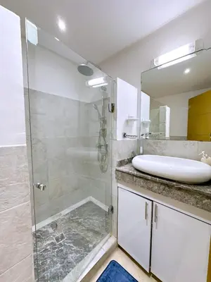 a bathroom with a glass shower and a sink at Cosy Hyper centre Bd Hassan 2 in Marrakech