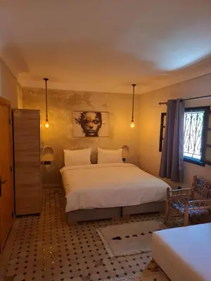 a bedroom with a large white bed and a window at Duplex Riad Abjaou in Marrakech