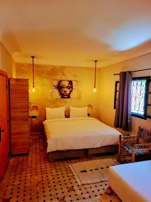 a bedroom with a large white bed and a window at Duplex Riad Abjaou in Marrakech