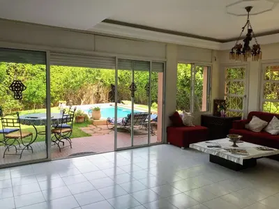 a living room with sliding glass doors and a pool at Riad sofia in Marrakech