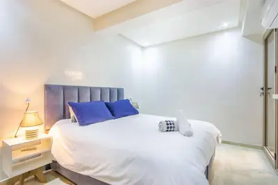 a bedroom with a large white bed with blue pillows at NEW! Plein Gueliz, wifi, terrasse in Marrakech