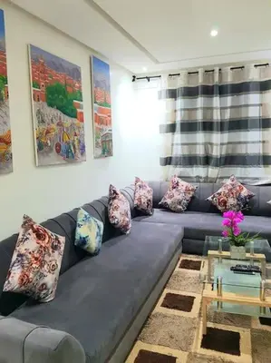 a living room with a blue couch with pillows at New! Appartement en plein centre ville in Marrakech