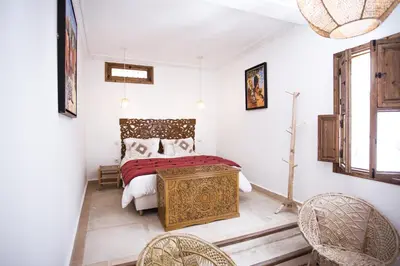 a bedroom with a bed and two chairs at Riad Bab Aljana in Marrakech