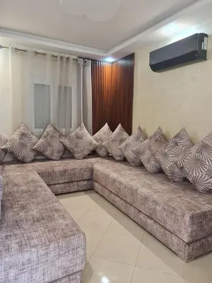 a large couch with pillows on it in a living room at Riad Jad - Sweet Duplex Appartement in Marrakech
