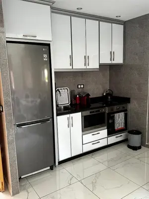 a kitchen with white cabinets and a stainless steel refrigerator at Riad Jad - Sweet Duplex Appartement in Marrakech