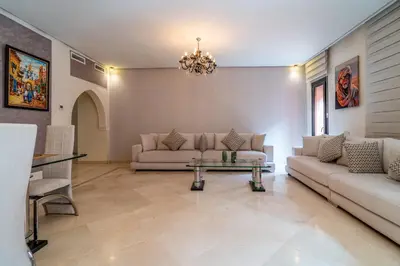 a living room with two couches and a table at Appartement Haut standing Gueliz Plaza in Marrakech