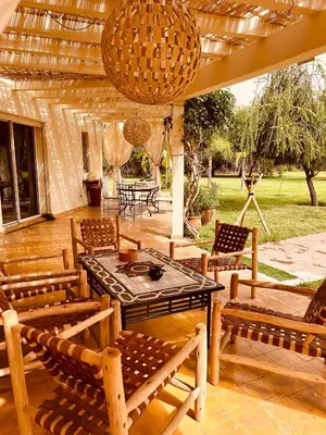a patio with chairs and a table and a ceiling at Séjour idéal a Marrakech - Villa spacieuse tout confort in Marrakech