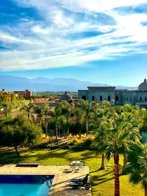 a view of a resort with a pool and palm trees at Séjour idéal a Marrakech - Villa spacieuse tout confort in Marrakech