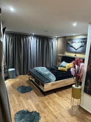 a bedroom with a bed with a painting on the wall at Appartement Luxueux au Rooftop à Guéliz in Marrakech