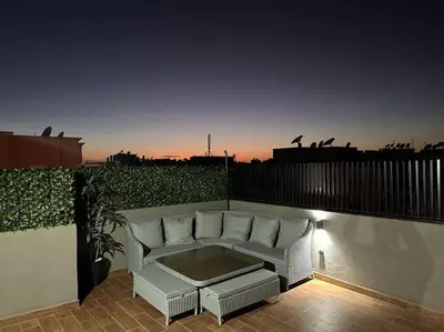 a white couch sitting on a balcony with a table at Appartement Luxueux au Rooftop à Guéliz in Marrakech