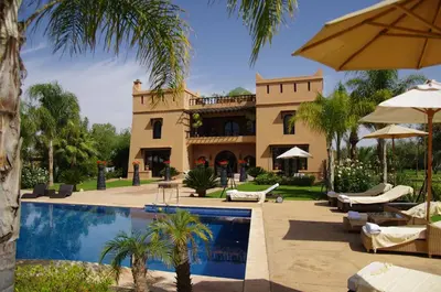 a house with a swimming pool in front of a house at Villa Malika Silvana in Marrakech