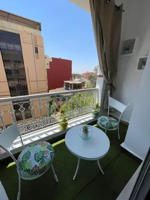 a balcony with two chairs and a table on a balcony at Joli appartement Gueliz centre ville in Marrakech