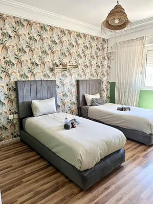a bedroom with two beds and a couch at Maison de ville avec piscine privée in Marrakech
