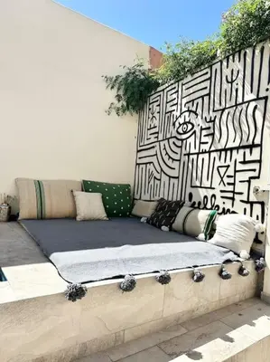 a couch sitting on the side of a wall at Maison de ville avec piscine privée in Marrakech