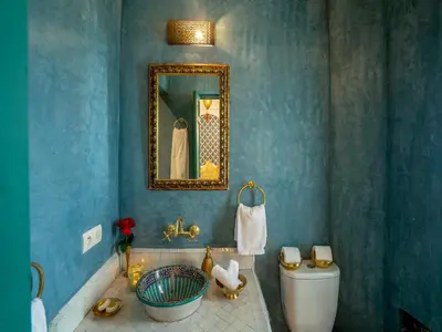a blue bathroom with a toilet and a mirror at Riad dada Messouda spa in Marrakech