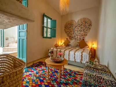a bedroom with a bed with a heart shaped wall at Riad dada Messouda spa in Marrakech