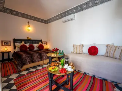a living room with two beds and a table at Riad dada Messouda spa in Marrakech