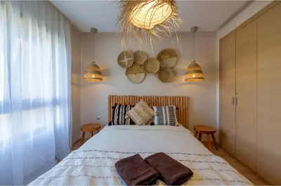 a bedroom with a bed and two chairs and a chandelier at Stylish Bliss - Dream Apartment in Marrakech