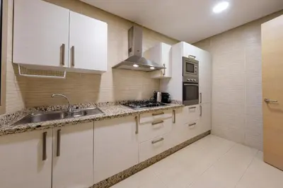 a kitchen with white cabinets and a sink at Stylish Bliss - Dream Apartment in Marrakech