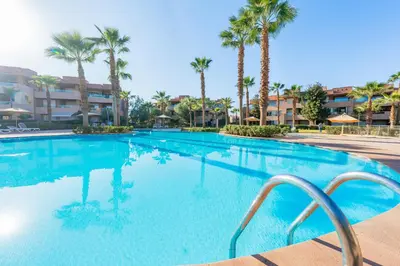 a large swimming pool with palm trees in a resort at Stylish Bliss - Dream Apartment in Marrakech