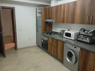 a kitchen with a washing machine and a microwave at Appartement spacieux & lumineux à Gueliz in Marrakech