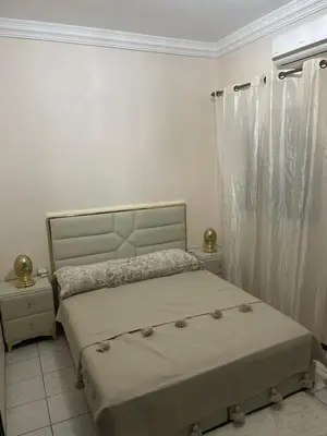a white bedroom with a bed and a window at Riad Aya in Marrakech