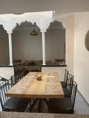 a wooden table with chairs in a room at Riad Aya in Marrakech