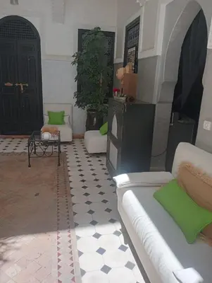 a living room with a couch and a table at Le riad de l'étoile ocre - COTG in Marrakech